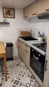 a kitchen with a sink and a stove top oven at Appartement individuel en maison in Beaumont-sur-Oise +6 photos