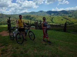 two people standing with their bikes in the grass at Sobantu Guest Farm in Piggs Peak