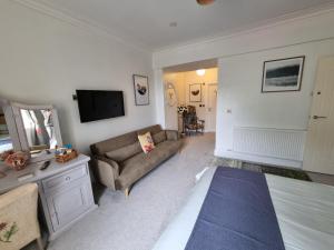 uma sala de estar com um sofá e uma televisão em The Snug Lytham em Lytham St Annes