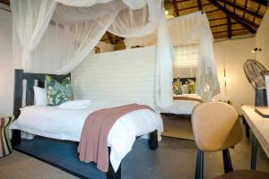 ein Schlafzimmer mit einem weißen Bett mit Baldachin in der Unterkunft Africa on Foot in Klaserie Private Nature Reserve