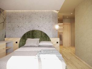 una camera con un grande letto con testiera verde di Flos Hotel a Moena