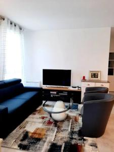 a living room with a couch and a tv at Appartement d'une chambre avec vue sur la ville terrasse amenagee et wifi a Saint Germain en Laye in Saint-Germain-en-Laye
