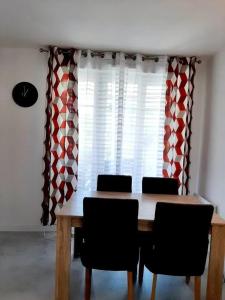 a dining room with a table and chairs and curtains at Appartement d'une chambre avec vue sur la ville terrasse amenagee et wifi a Saint Germain en Laye in Saint-Germain-en-Laye