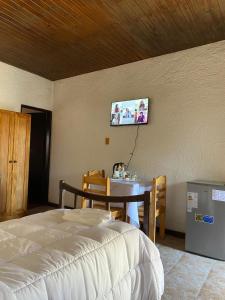 a bedroom with a table and a tv on the wall at Posada TyM in Trinidad