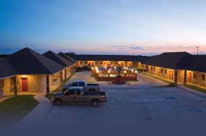 a truck parked in a parking lot in front of a building at Guest Inn San Benito/Harlingen in San Benito