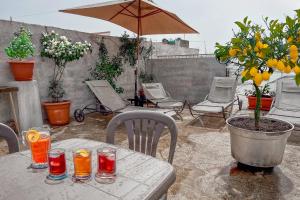 una mesa con bebidas y una sombrilla en el patio en Casa Grasso, en Vittoria