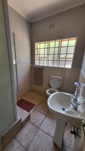 a bathroom with a sink and a toilet at ENTIRE LUXURY APARTMENTS in Mbabane