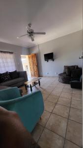 sala de estar con sofás y ventilador de techo. en ENTIRE LUXURY APARTMENTS en Mbabane