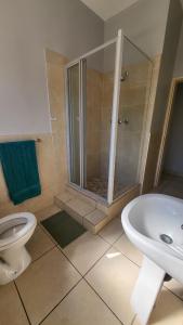 a bathroom with a shower and a toilet and a tub at ENTIRE LUXURY APARTMENTS in Mbabane