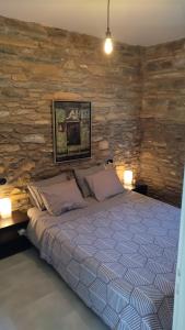 AegeanDeepBlue2 في Apróvaton: غرفة نوم بسرير وجدار حجري