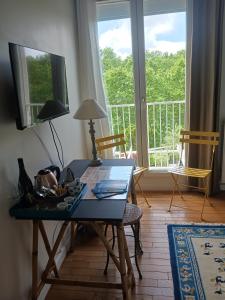 una mesa en la sala de estar con vistas a un balcón en Chambre d'hôte Bords de Garonne, en Burdeos
