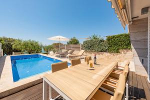 a patio with a table and chairs next to a swimming pool at Villa Camelia ZadarVillas in Petrcane +39 photos