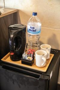 a coffee maker and a bottle of water and cups at 49 Sunrise Lodge in Għajnsielem