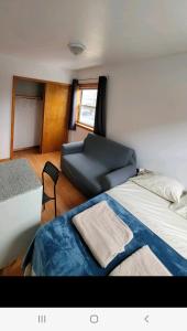 - une chambre avec un grand lit et un canapé dans l'établissement Comfortable rooms in NYC near the train, à Woodside