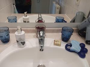 un lavabo con cepillo de dientes y gafas. en Chambre d'hôte Bords de Garonne, en Burdeos