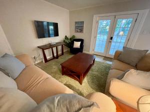 a living room with two couches and a table at Cottage Hill Comfort in Mobile