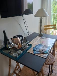 una mesa con tetera y tazas. en Chambre d'hôte Bords de Garonne, en Burdeos