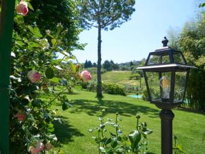 een straatlicht in een tuin met rozen bij Begonia appartamento in villa in Macerata