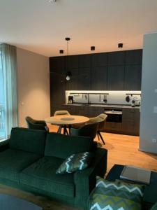 sala de estar con sofá verde y mesa en Marina Apartment am See mit Pool und Sauna, en Bad Saarow