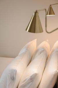 eine Lampe und weiße Kissen an der Wand in der Unterkunft Rodi Studios in Karavádhos