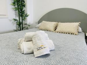 a pile of towels sitting on top of a bed at Estudio Jimena Carabeo en el centro de Nerja in Nerja