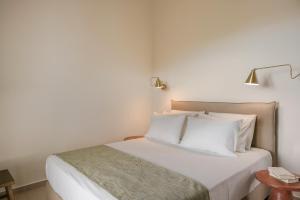 1 dormitorio con 1 cama con sábanas y almohadas blancas en Rodi Studios en Karavadhos
