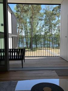 a bench on a porch with a view of a deck at Marina Apartment am See mit Pool und Sauna in Bad Saarow