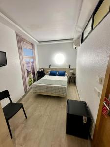 a bedroom with a bed and a desk and a chair at Hostal Castilla II Puerta del Sol in Madrid
