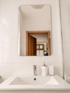 W łazience znajduje się biała umywalka i lustro. w obiekcie ZielonoMi w mieście Zieleniak