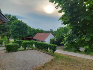 a garden with a house and a hedge at Campingrosengarten in Cserszegtomaj