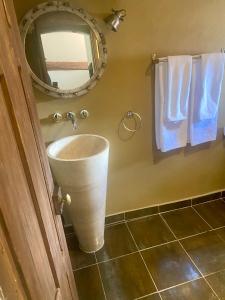 ein Badezimmer mit einem Waschbecken, einem Spiegel und Handtüchern in der Unterkunft La Bouscatière in Moustiers-Sainte-Marie