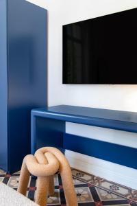 a blue desk with a tv and a chair at Mila - Boutique Hotel in Haifa