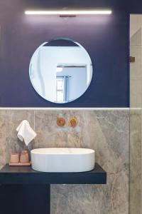 a bathroom with a white sink and a mirror at Mila - Boutique Hotel in Haifa