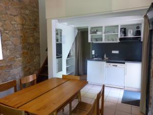 kuchnia i jadalnia z drewnianym stołem w obiekcie Terres de France - Le Domaine des Vans w mieście Chambonas