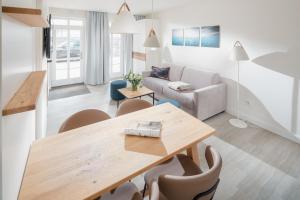 a living room with a wooden table and chairs at Nordstrandperle Ap S5 in Norderney