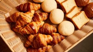 a bunch of croissants and breads on a basket at Daiwa Roynet Hotel Sendai Ichibancho PREMIER in Sendai