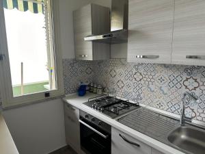 una cucina con piano cottura e lavandino di CH Exclusive Apartments a Cefalù