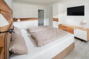 a bedroom with a bed and a tv on a wall at Nordstrandperle Ap S3 in Norderney