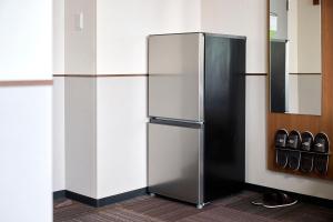 a stainless steel refrigerator in a room at Hotel 1-2-3 Kurashiki in Kurashiki