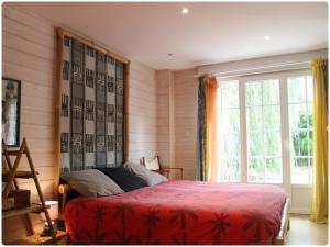 Un dormitorio con una cama roja y una ventana. en Villa Roma, en Montluçon 13 fotos más