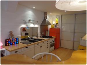 Una cocina con un fregadero y un refrigerador rojo. en Villa Roma, en Montluçon