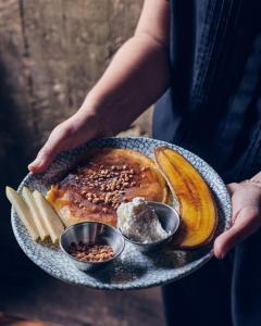 a person holding a plate of food with bananas and butter at Fabric Hotel - an Atlas Boutique Hotel in Tel Aviv