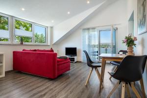 uma sala de estar com um sofá vermelho e uma mesa em Haus Sohl 2 em Friedrichshafen