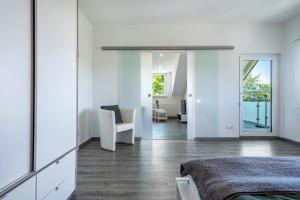 um quarto com uma cama e uma cadeira num quarto em Haus Sohl 2 em Friedrichshafen