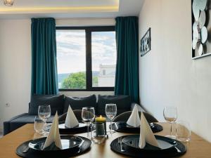 a dining room table with wine glasses and a couch at ORA SeaView in Balchik