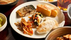 a white plate with food on a table at Daiwa Roynet Hotel Sendai Ichibancho PREMIER in Sendai