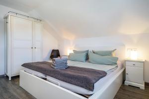 a bedroom with a large white bed with blue pillows at Haus Sohl 1 in Friedrichshafen