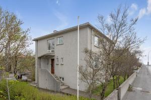 una casa bianca con una porta rossa su una strada di Audur Guesthouse a Reykjavik