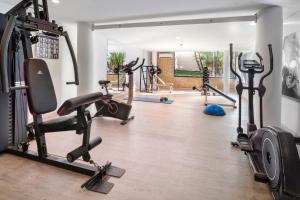 a gym with treadmills and cardio machines at Cala Millor Garden Hotel - Adults Only in Cala Millor