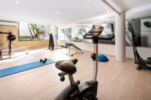 a gym with a exercise bike and a treadmill at Cala Millor Garden Hotel - Adults Only in Cala Millor